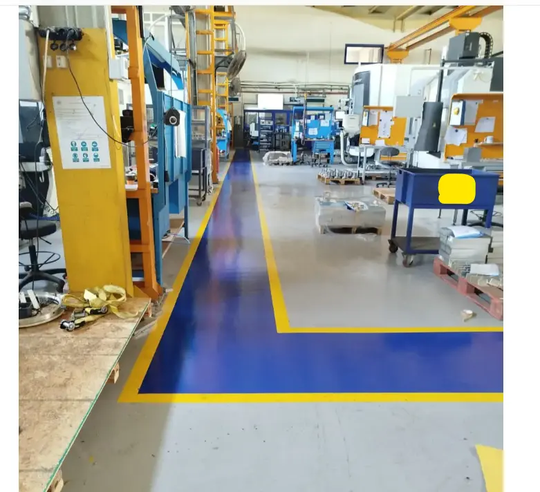 Marka bilgisi gizlenmiş fabrikada mavi ve sarı yürüyüş yolları