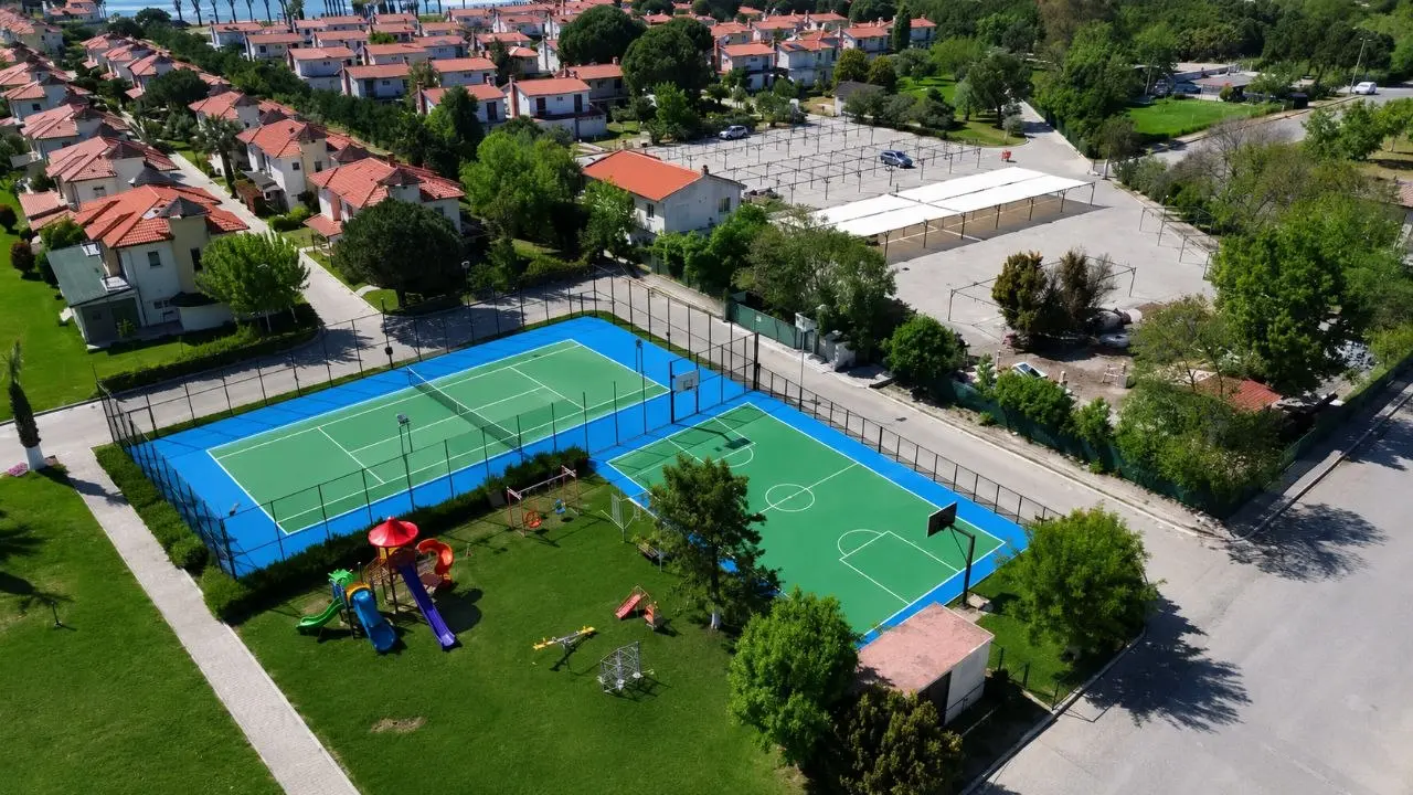 Basketbol sahası ve tenis kortlarının tamamını gösteren açık spor alanı